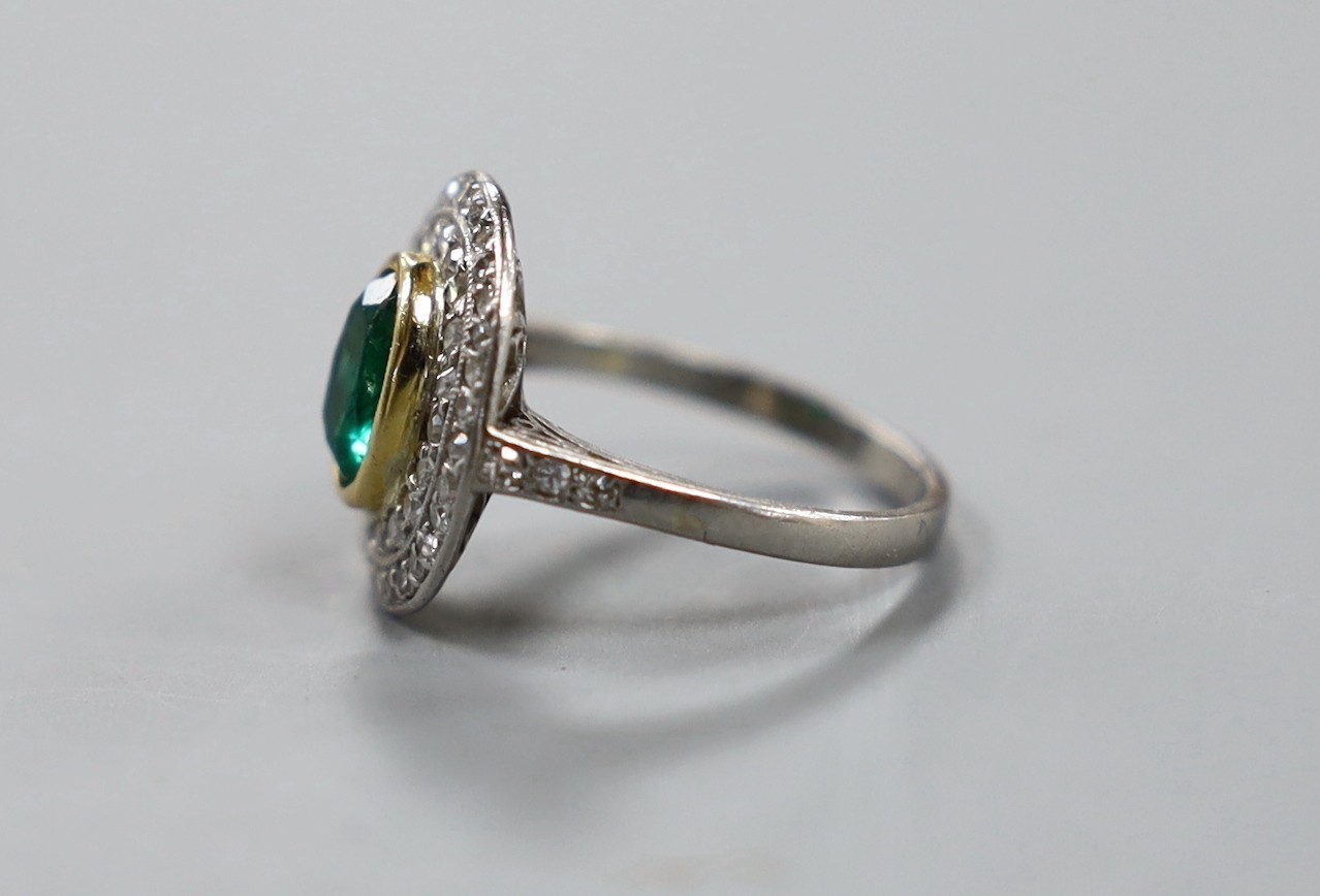 A white metal, emerald and diamond set oval cluster ring, size I/J, gross weight 3.8 grams.